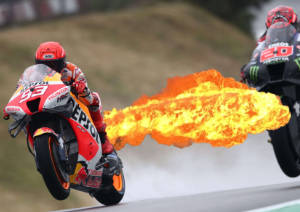 Marc Marquez with flames shooting out the back of his bike